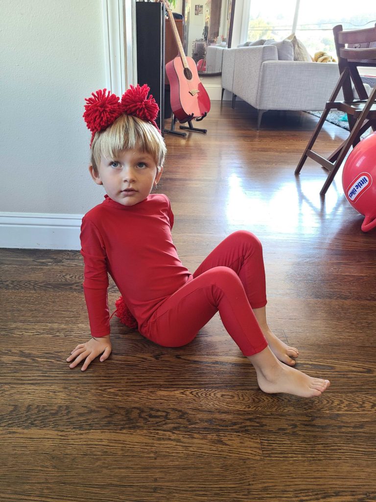 A young boy in a homemade red gummy bear costume