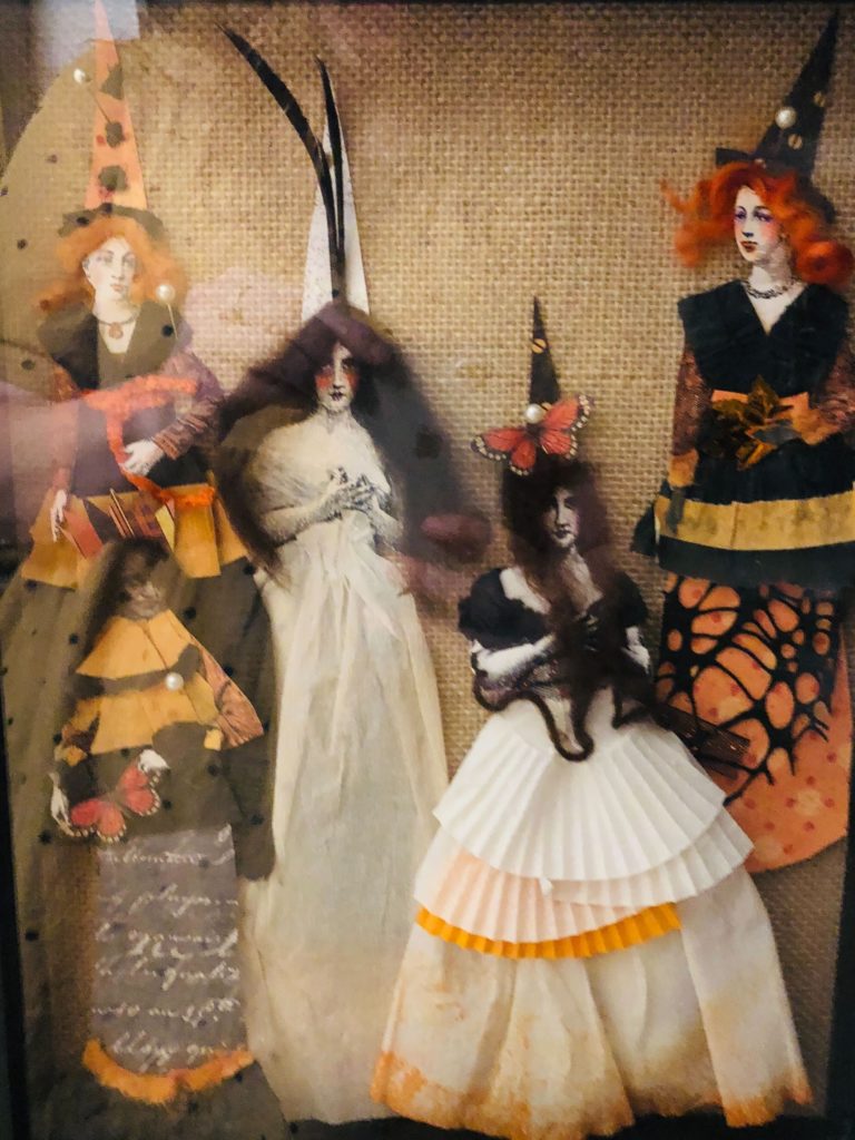 A small collection of paper doll witches in black, orange, and white made from Victorian cut outs