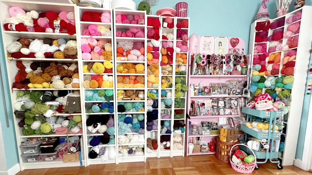 Colorful wall of shelves filled with yarn and other craft supplies.