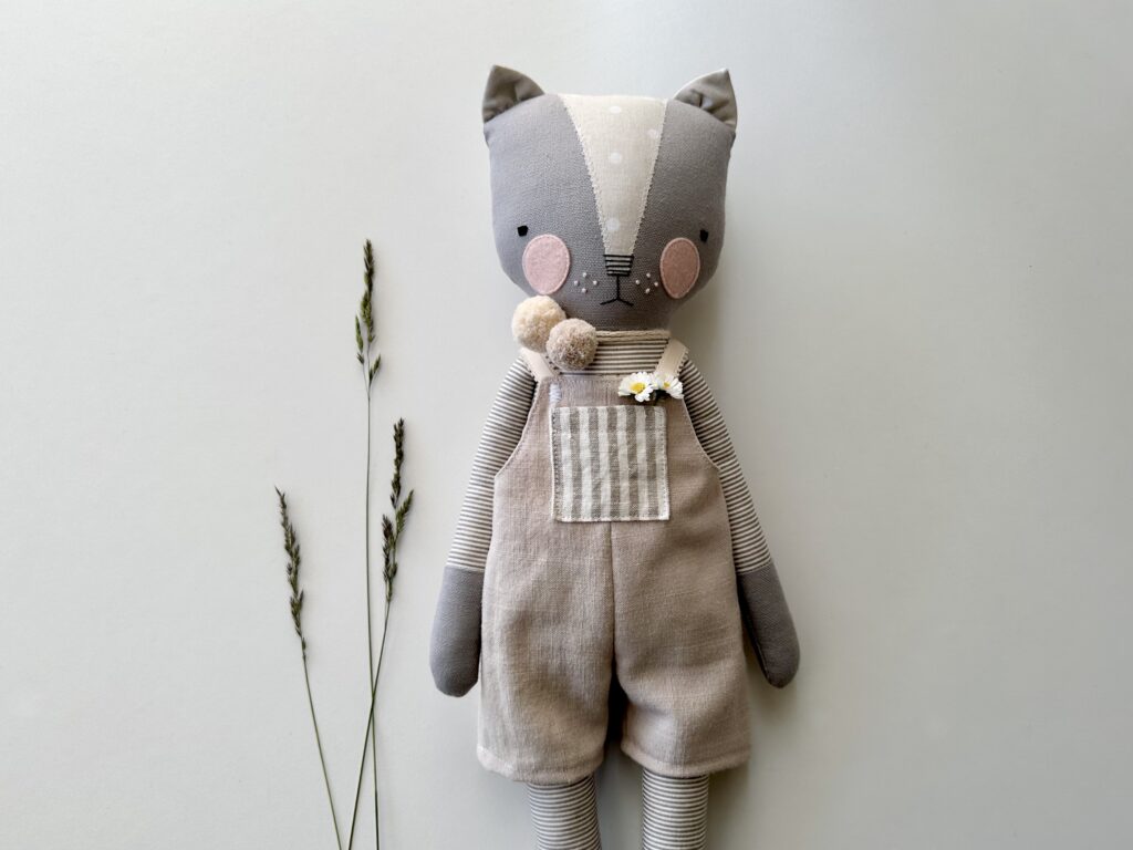 image close up photo of luckyjuju cat doll wearing beige handsewn overalls