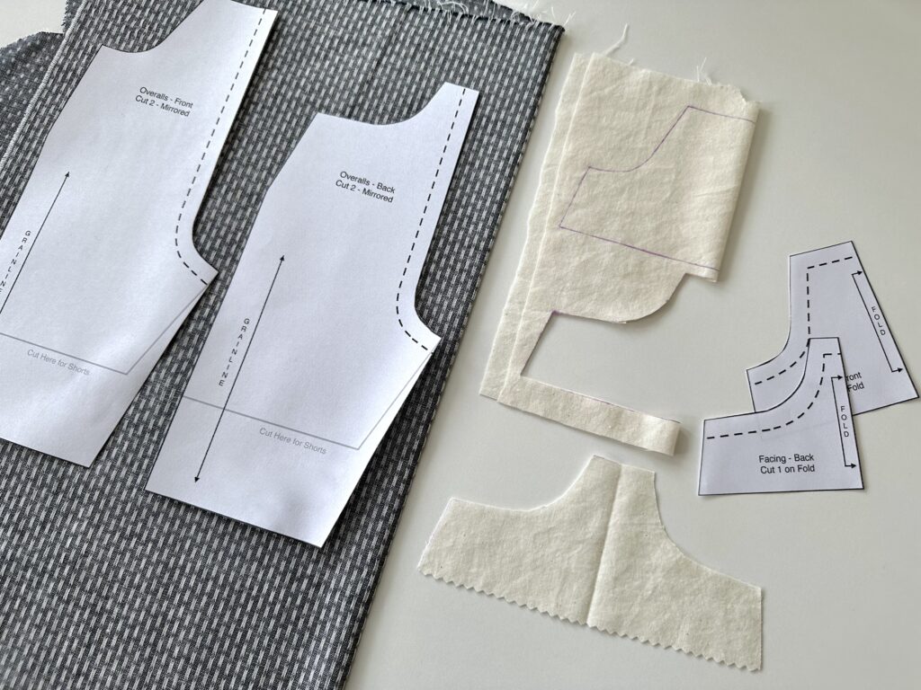 image of grey patterned fabric and paper sewing pattern pieces on a white table