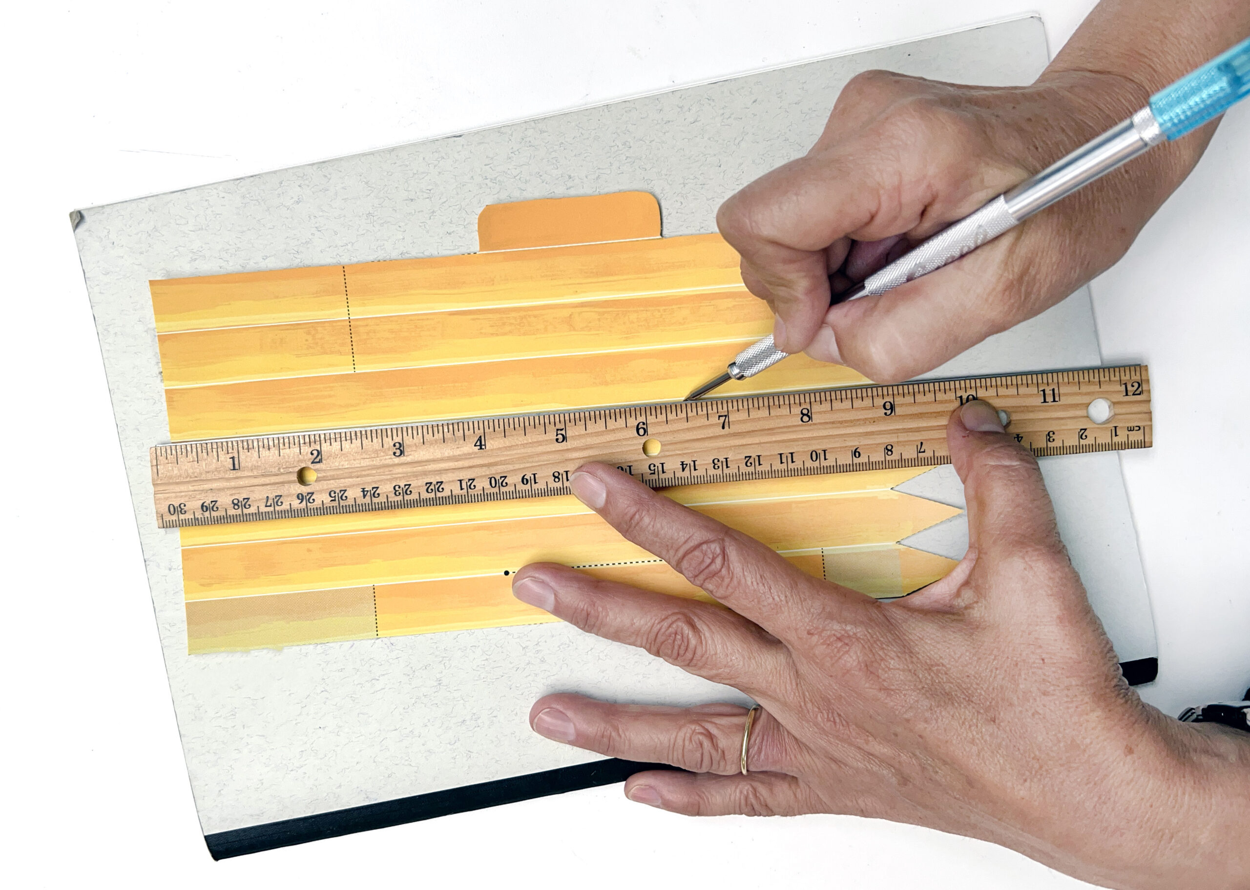 image of scoring a paper template with a ruler and utility knife