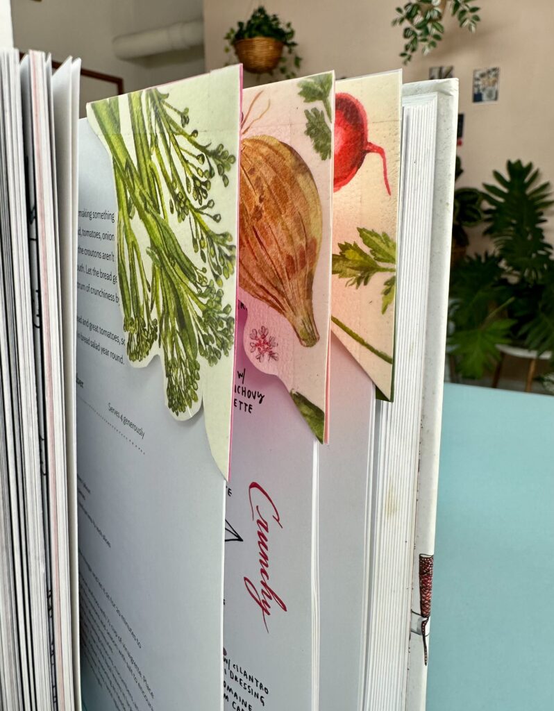 images of book pages with corner bookmarks on them depicting watercolor paintings of different vegetables