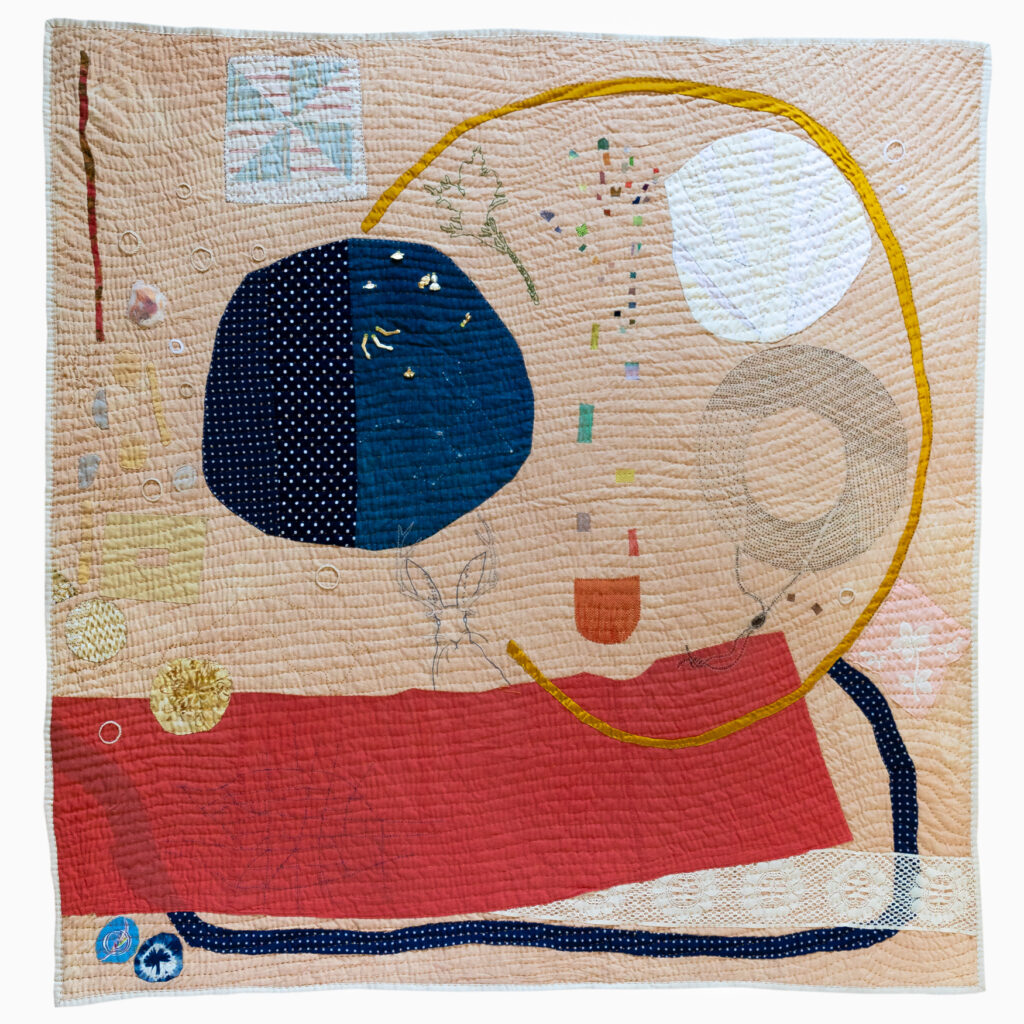 images of handmade quilt with many colorful large patches in dark blue and brick red and visible hand stitching