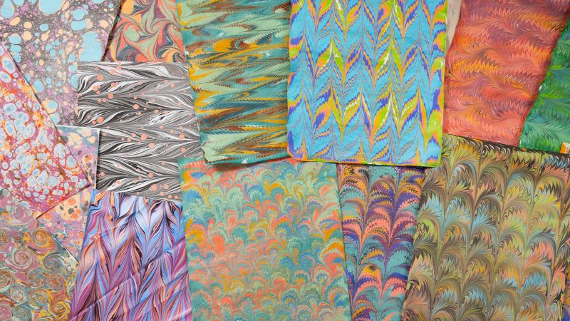image of lots of overlapping papers covered in colorful swirls of painted marbling
