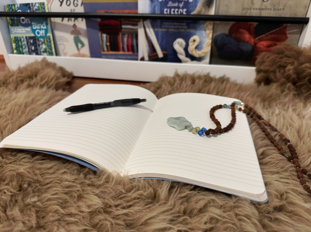 image of an open journal with blank pages, a pen on one side, a crystal necklace on the other, to prepare you for an exercise in activating a beginner's mind